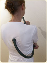 Een vrouw die haar eigen rug masseert met behulp van een massage stok